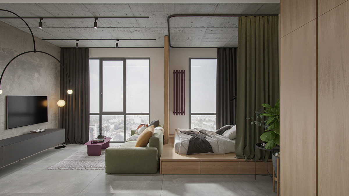 Sofa màu xanh lá dịu mát trở thành vách ngăn phân chia phòng ngủ nhỏ với không gian tiếp khách. Rèm cùng tông màu tạo sự riêng tư thiết yếu.