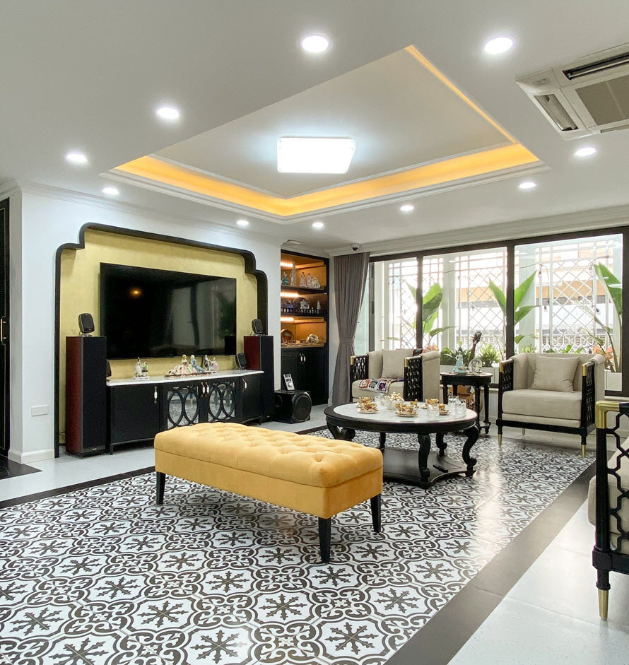 Phòng khách nhà phố phong cách Indochine rộng thoáng với ánh sáng tự nhiên ngập tràn. Nội thất sắc vàng ấm áp làm sáng bừng không gian.