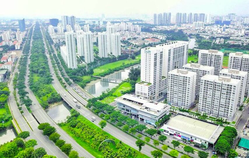 Hình ảnh một góc thành phố nhìn từ trên cao với các tòa cao ốc xen kẽ khu dân cư thấp tầng, cây xanh