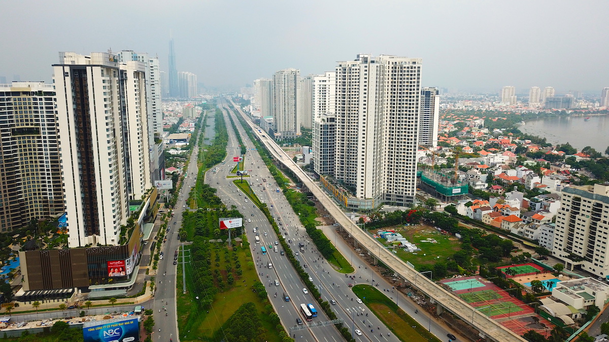 Hình ảnh một góc thành phố nhìn từ trên cao với các tòa chung cư cao tầng xen kẽ khu dân cư thấp tầng, cây xanh, đường phố