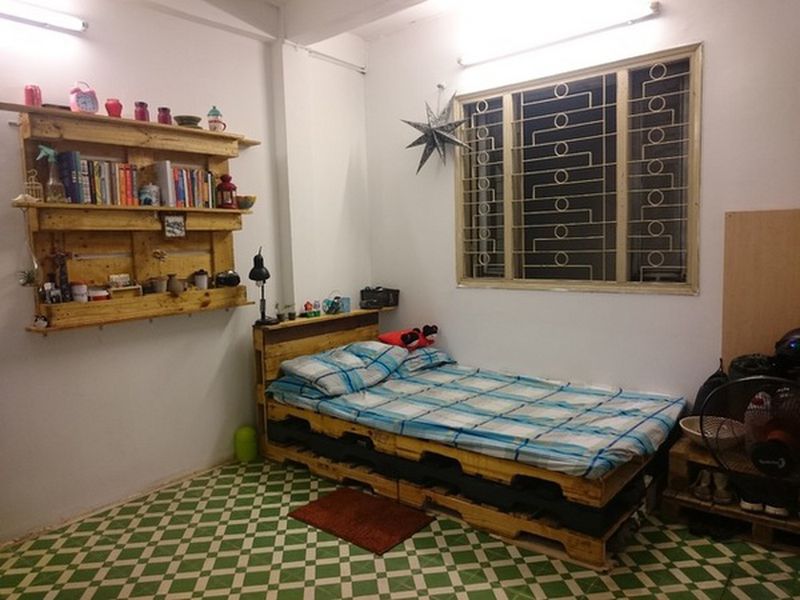 Hình ảnh phòng trọ với giường trải nệm kẻ sọc, giá sách gắn tường mình họa cho phòng trọ Bình Thạnh