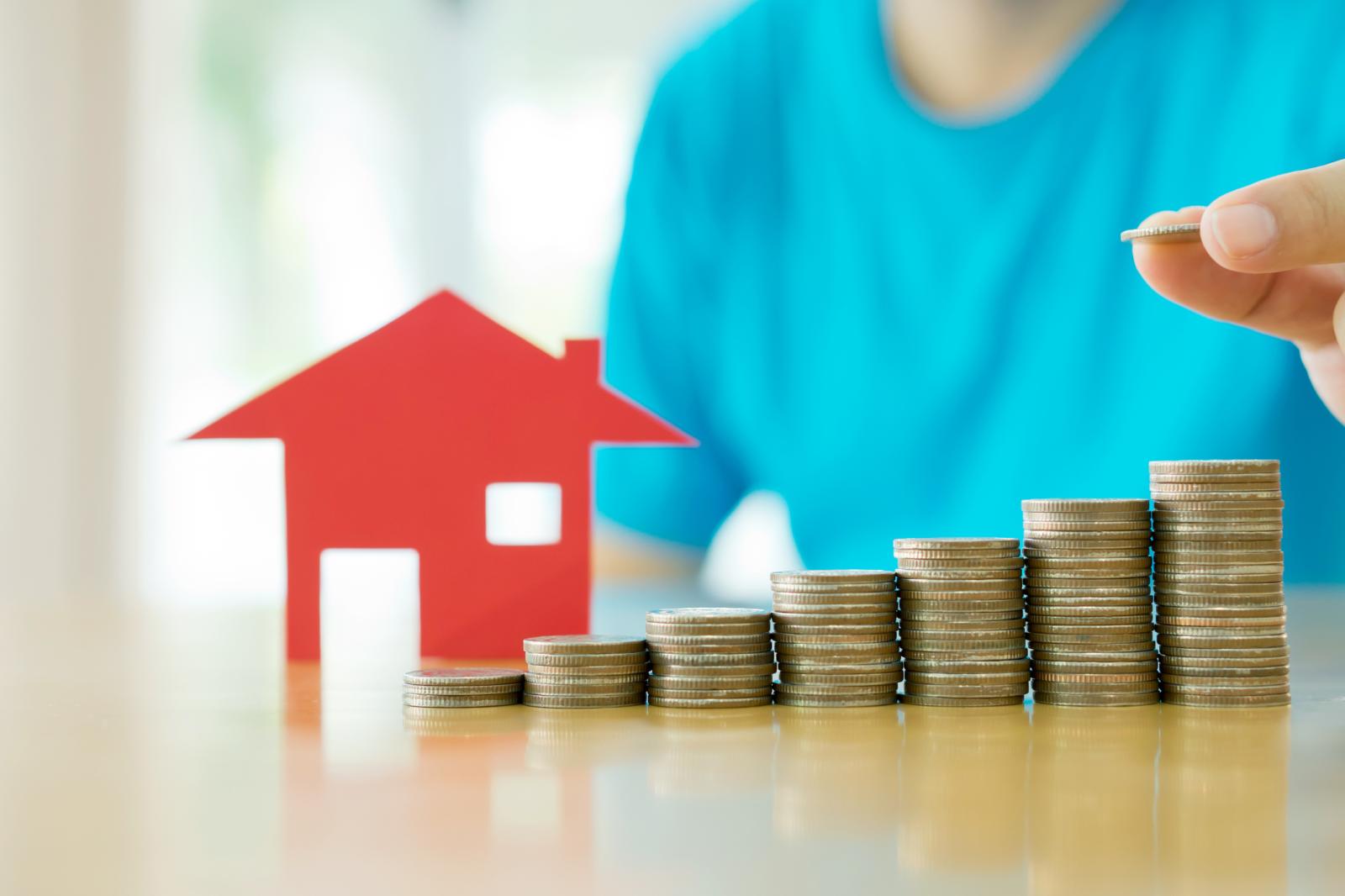 mô hình ngôi nhà mái đỏ, các cọc tiền xu minh họa cho tăng tiền thuê nhà