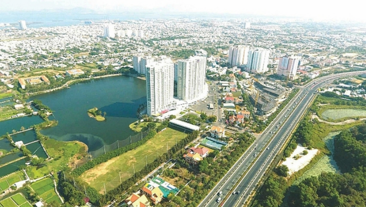 Một góc thành phố nhìn từ trên cao với hồ nước, các tòa cao ốc, xen kẽ cây xanh